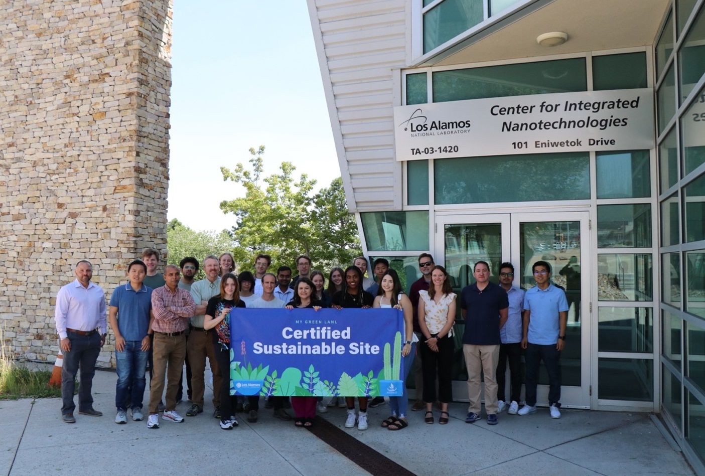 Members of the Center for Integrated Nanotechnologies with the banner proclaiming the center’s “My Green LANL” certification